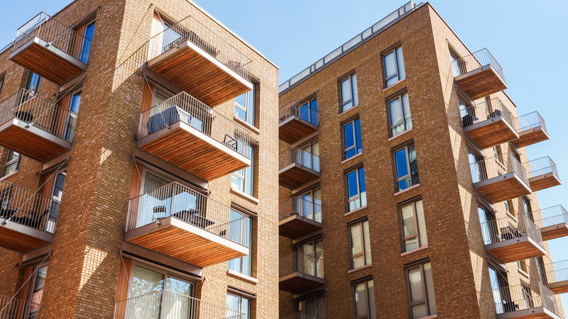 Moderna lägenhetshus med balkonger och stora fönster.