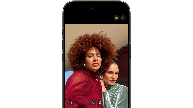 iPhone Air som visar två personer i moderiktiga kläder, en med lockigt rött hår i röd blus och en i grön topp.