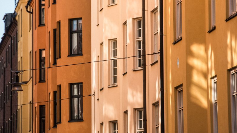 Äldre hus i olika färger i stor stad.