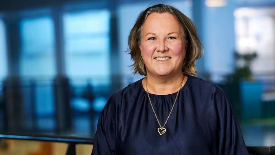 Linda Ekenär Mägi, affärsutvecklare på Tele2 Företag. Hon är klädd i mörkblå blus och har ett halsband med ett hjärta. Hon har ljusbrunt hår och ler. I bakgrunden syns ett kontorslandskap i blå toner.