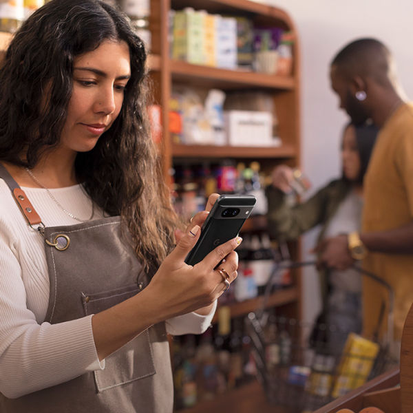 Kvinna i en affär med en Google Pixel 8 i handen