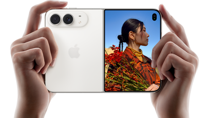 Två händer håller en vit iPhone Duo horisontellt som en traditionell kamera, med baksidan och skärmen synliga. Skärmen visar en kvinna med röda blommor.
