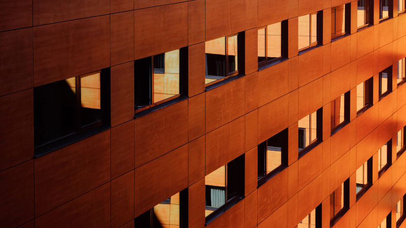 Modernt kontorshus med stora fönster och orange husvägg.