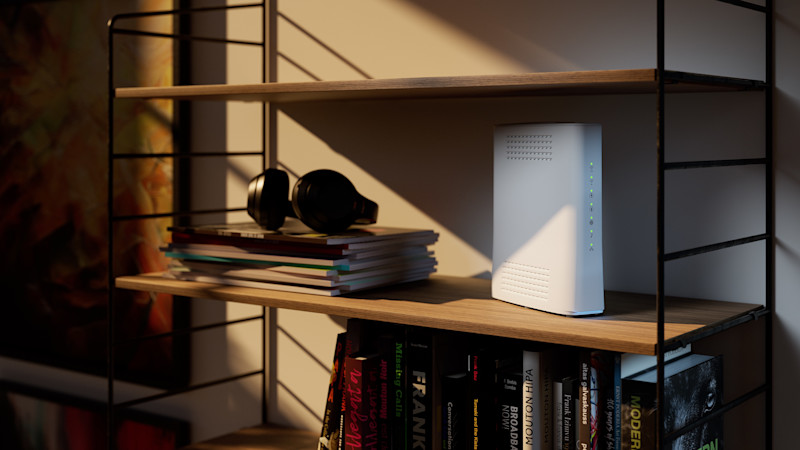 En vit trådlös router placerad på en bokhylla tillsammans med böcker och magasin. På hyllan ovanför ligger ett par svarta hörlurar på en bunt färgglada tidskrifter. Bakgrunden visar en varm kvällsbelysning som kastar skuggor över väggen och en abstrakt tavla i varma färger. Miljön ger ett modernt och hemtrevligt intryck.