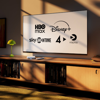 TV-skärm som visar logotyper för streamingtjänster: HBO Max, Disney+, Sky, Showtime, 4 och Viaplay på ett träbord.