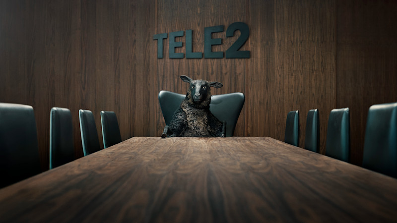 Fåret Frank sitter ensam vid ett konferensbord med Tele2-loggan i bakgrunden