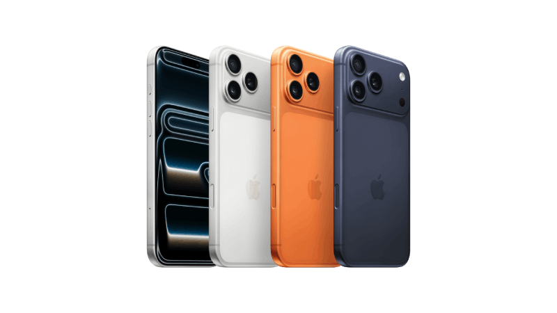 Fyra iPhone 17 Pro Max-mobiler på rad, i färgerna silver, orange och mörkblått. Tre av dem har baksidan vänd mot kameran. De har aluminiumhölje, Apple-logotyp och tre kameror i övre vänstra hörnet. Den fjärde har skärmen mot kameran och visar ett abstrakt linjemönster i silver och svart.