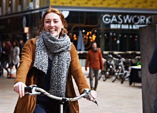 Smiling woman riding a bike.