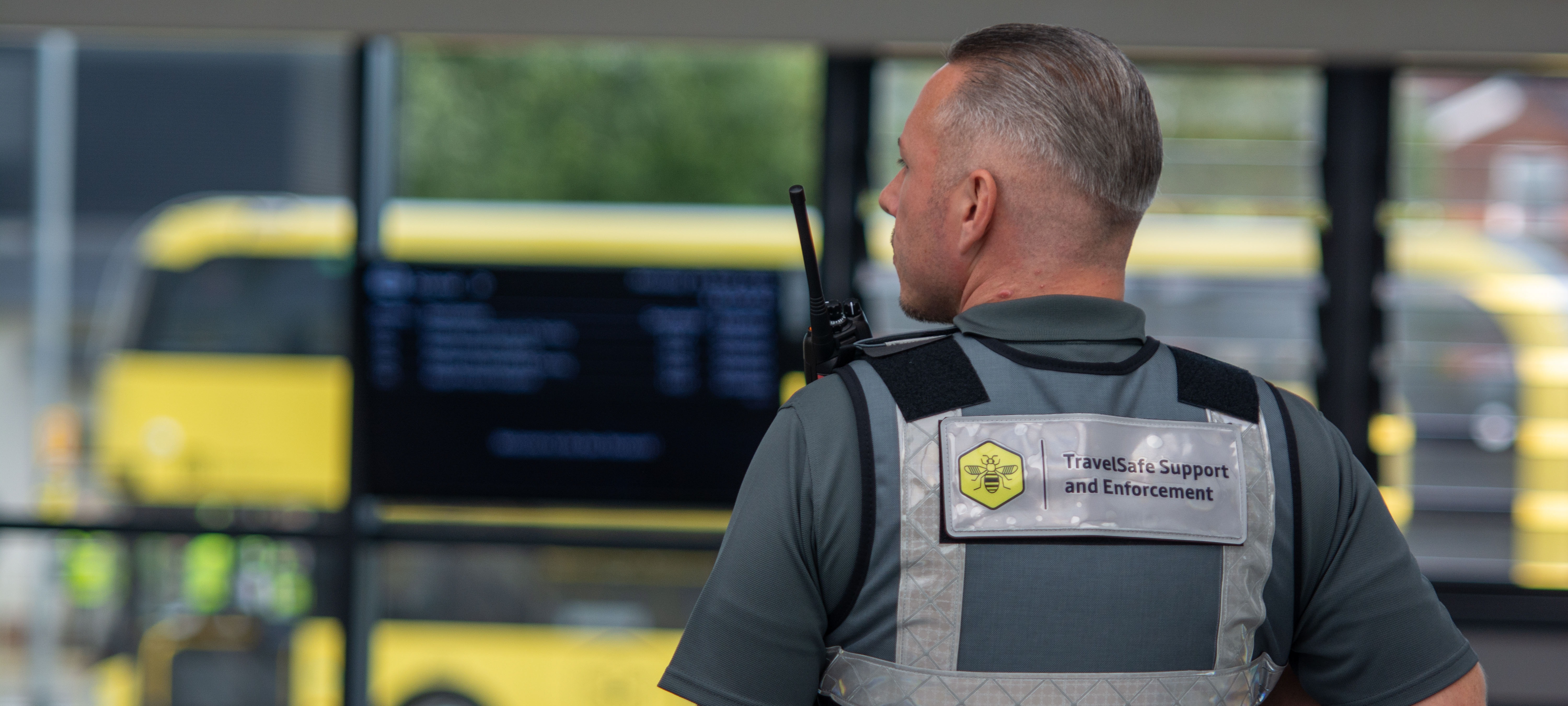 Travelsafe officer stood in front of a bee network bus
