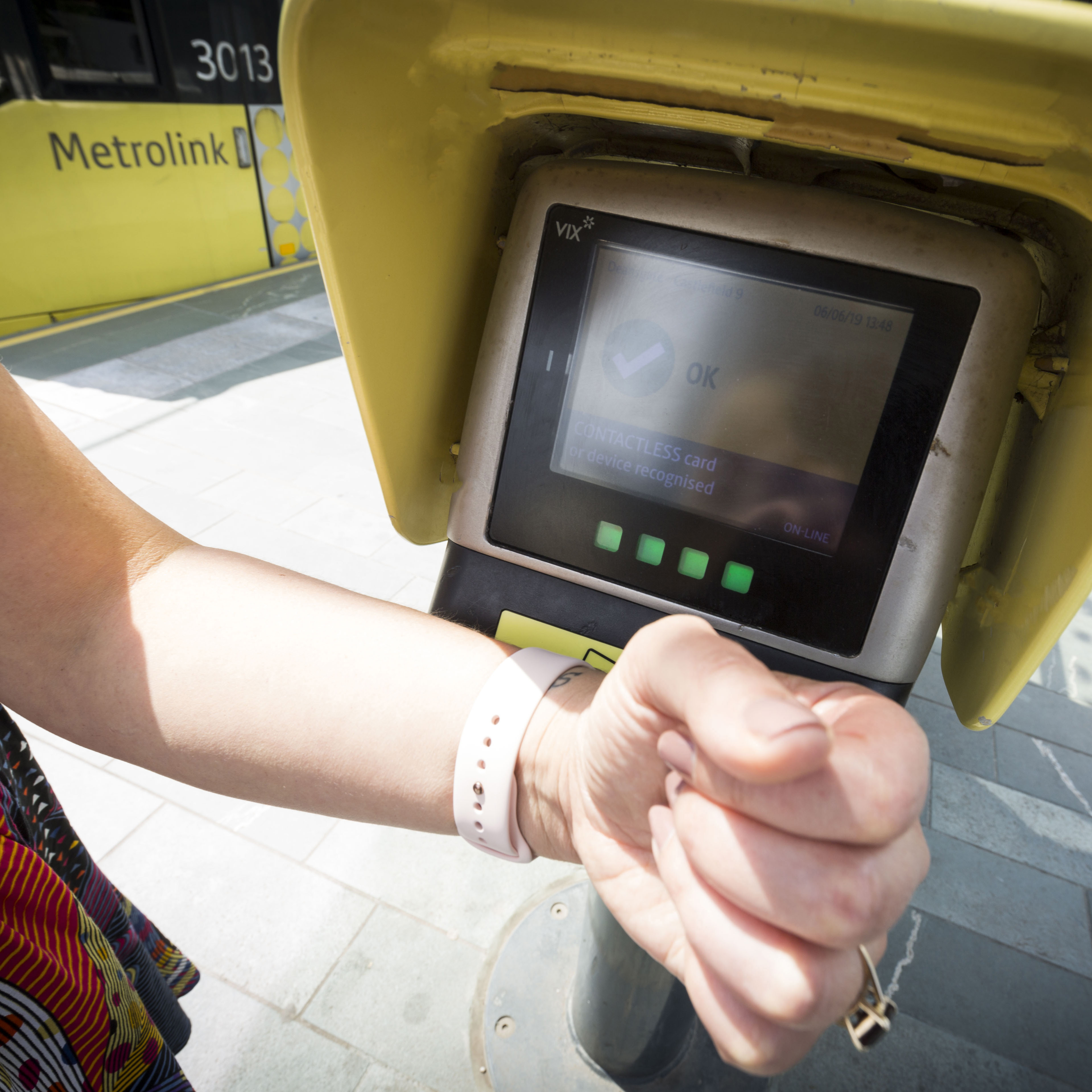 A person using their smart watch to pay for their tram using contactless