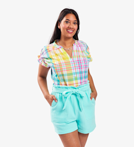 woman model wearing a multicoloured top with light blue shorts