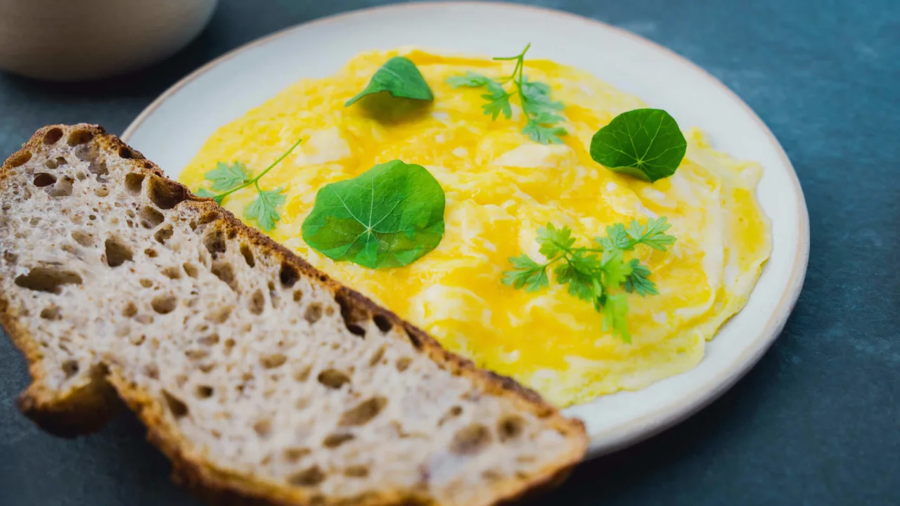 Freshly baked bread and scrambled eggs on a plate.