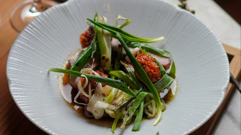 A delicious green food dish served on a white plate. 