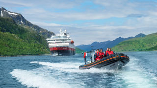 RIB boat in front of a Hurtigruten ship_16_9