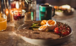 Plate with egg, crisp, tomatoes - orange juice and coffee cup