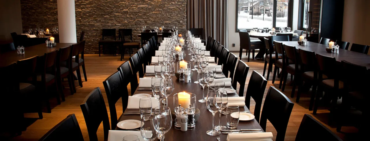 Restaurant with a set long table and snowy views outside at Quality Hotel™ Skifer in the norwegian ski town of Oppdal.