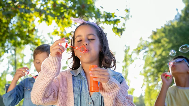 Kids playing outdoor with soap bubbles
