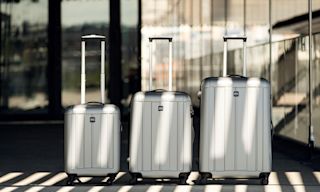 Three silver Rizzo suitcases in a row.