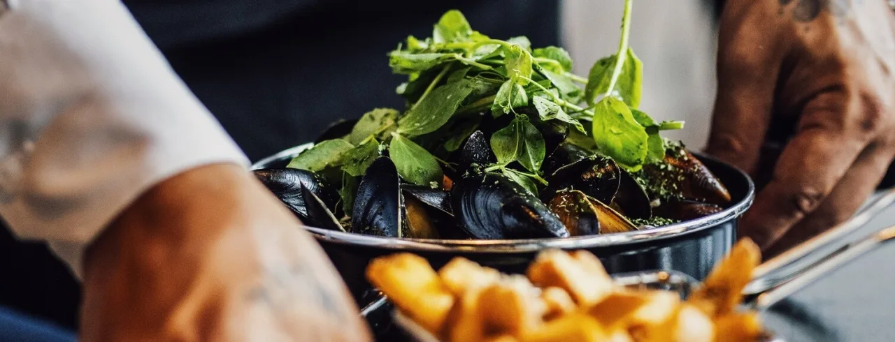 Fries and mussles being served at restaurant The Social Bar & Bistro.