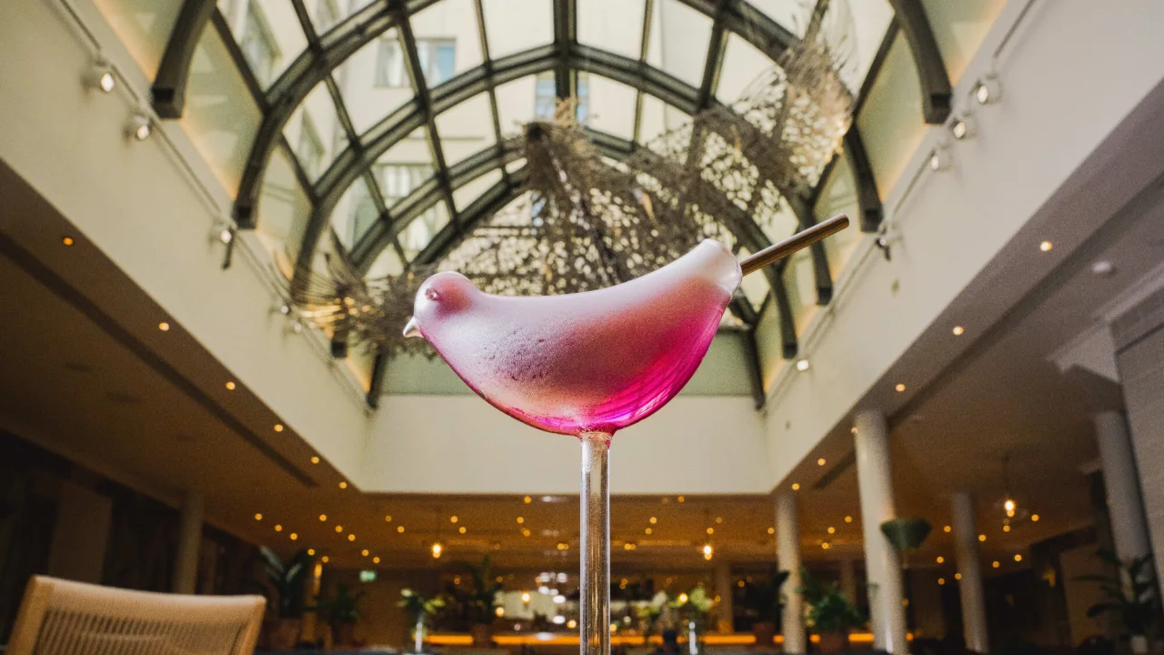 Pink cocktail in a glass formed as a bird at bar Wintergarden in Helsinki.