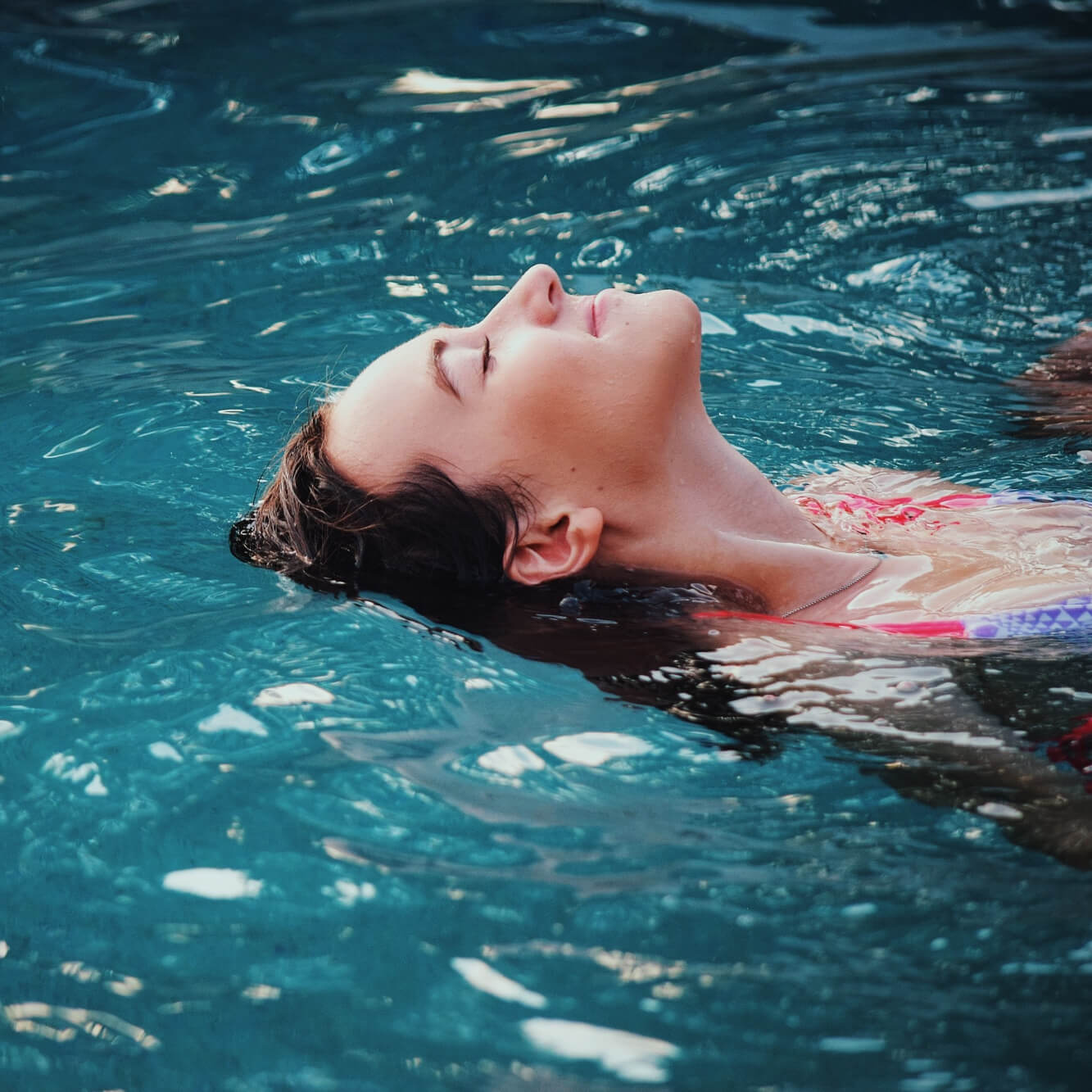 Kvinna kopplar av i en pool.