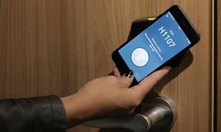 A hotel guest unlocks the door with a mobile key