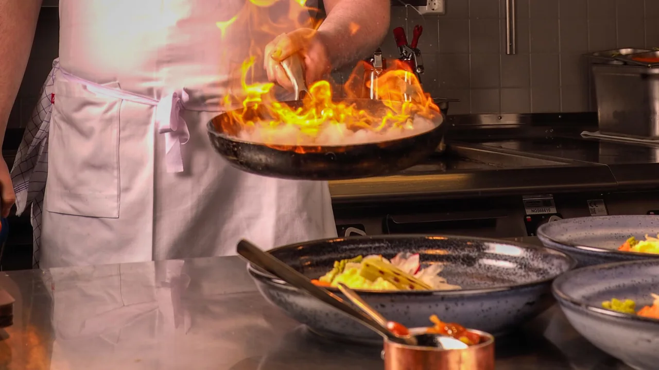 Chef in kitchen with flames, at The Social Bar & Bistro Qaulity Hotel Ramsalt in Bodø.