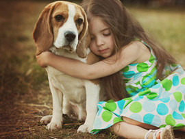 sad little girl hugging beagle