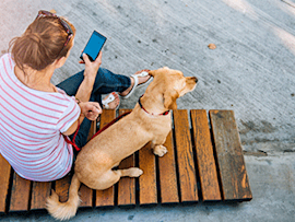 girl on the phone sitting with her dog