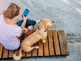 girl on the phone sitting with her dog