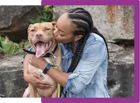 girl hugging and kissing her dog