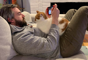 A cat sitting with it's pet parent ready to enjoy a long, happy life.