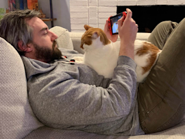 A cat sitting with it's pet parent ready to enjoy a long, happy life.