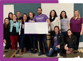 Embrace employees presenting a charity donation check