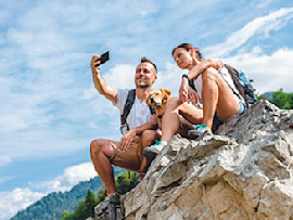 dog and people taking photo on rock ledge