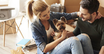 young couple unpacking with their yorkshire terrier