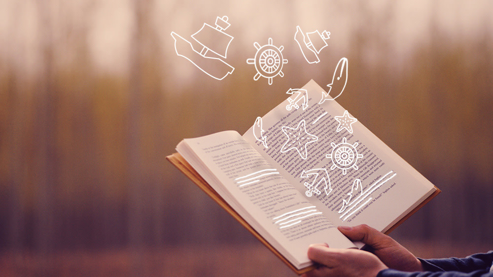 hands holding a open book with illustrated items flying out