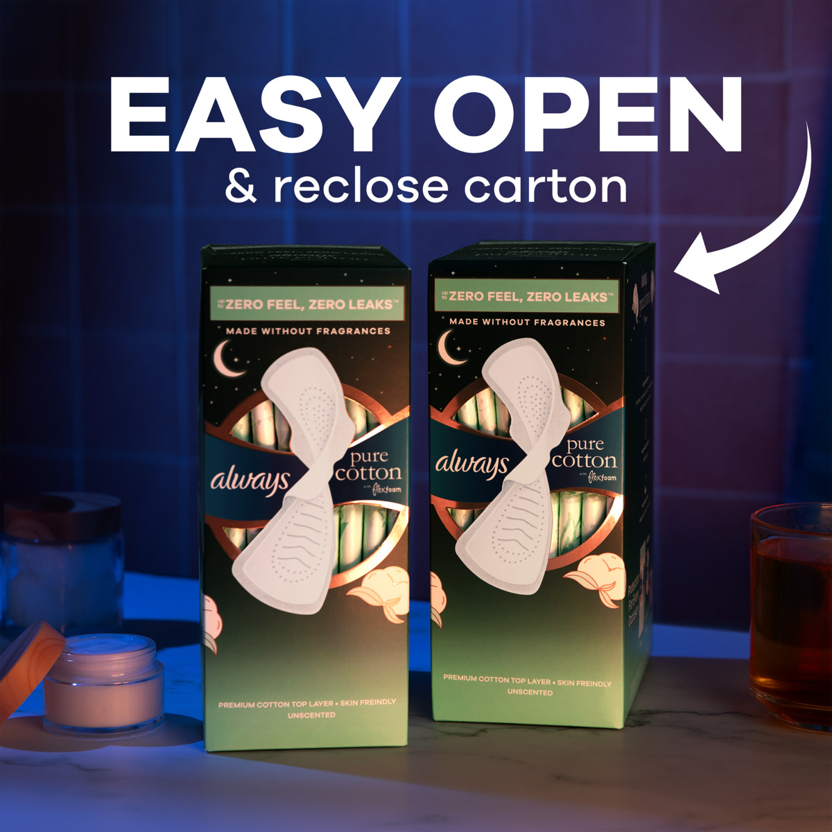 Photograph of two Always Pure Cotton product cartons placed side by side on a surface with a dark blue background. Text "EASY OPEN & reclose carton" appears above, highlighting the packaging feature for convenience and resealability.