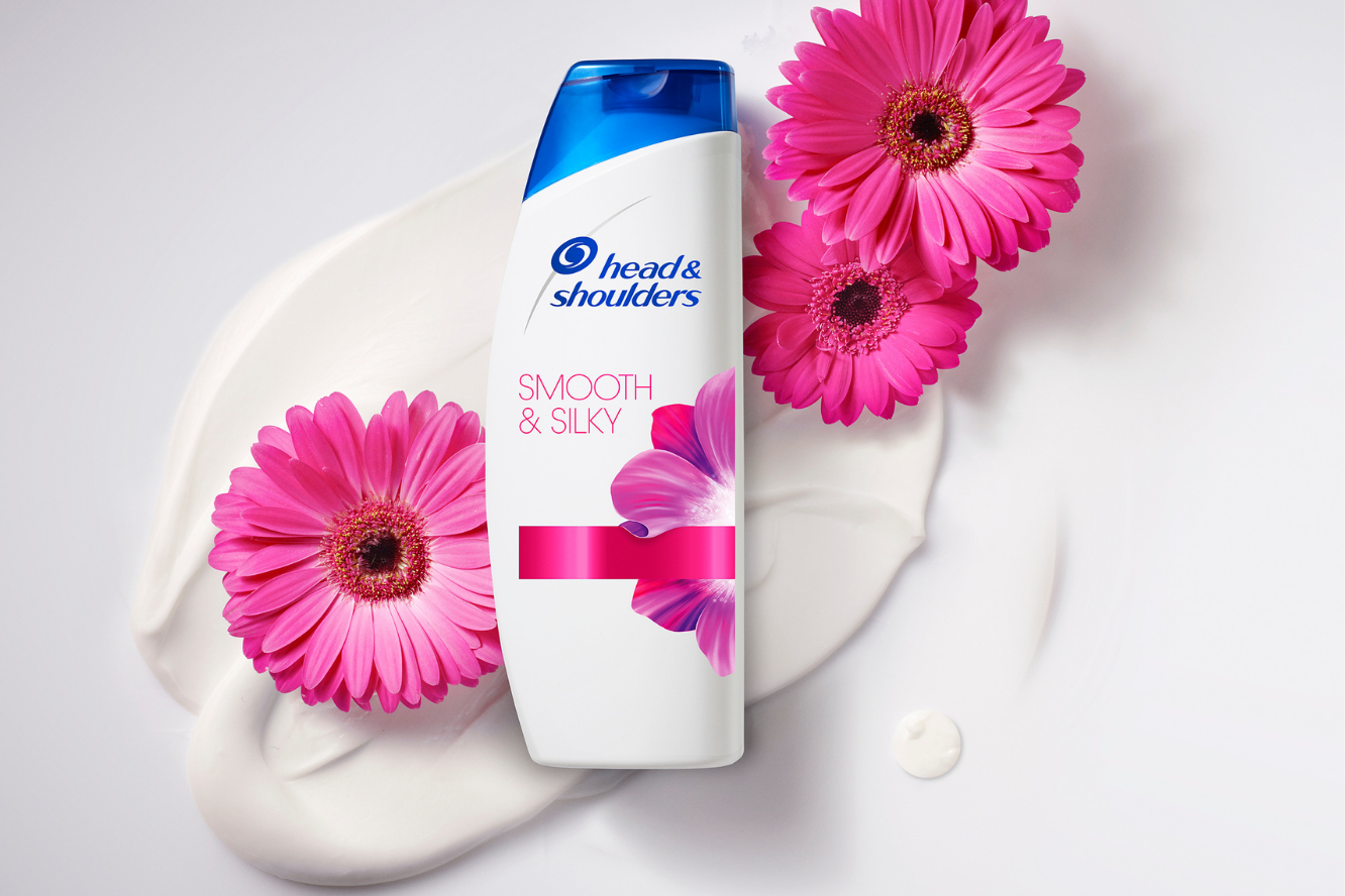 bouteille de shampooing avec fleurs roses sur fond blanc