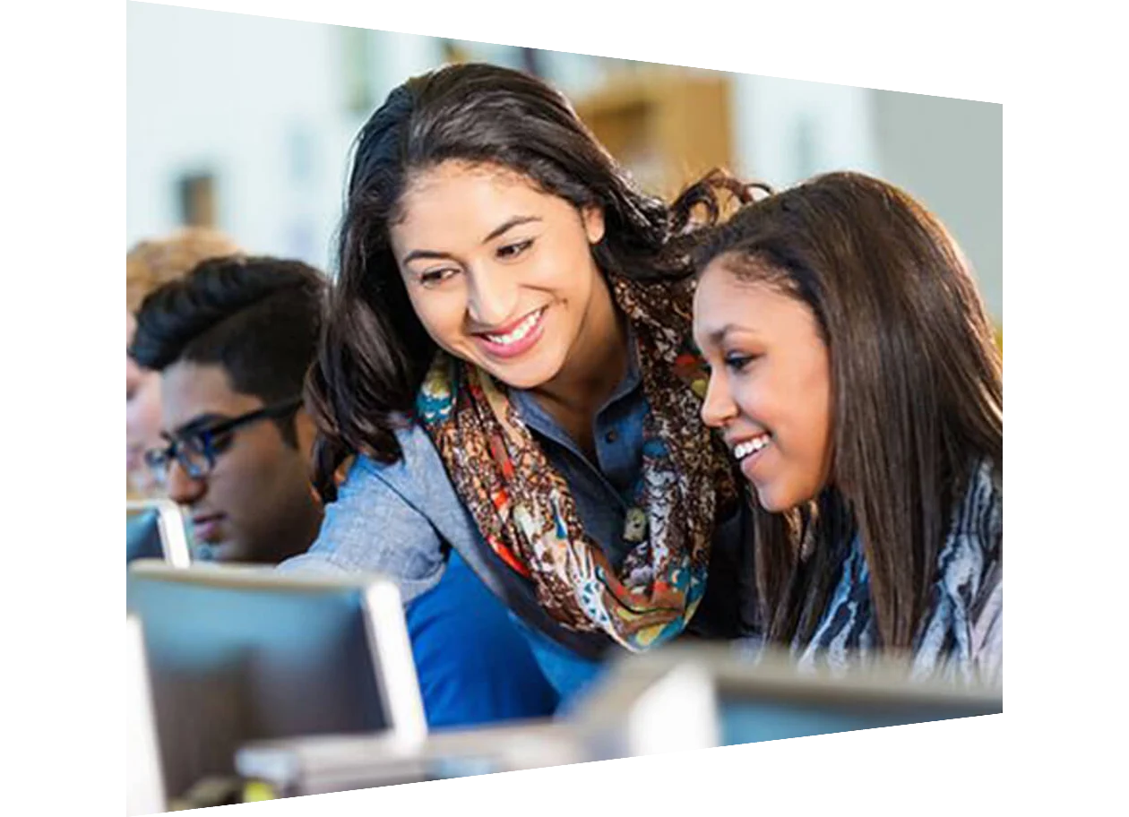 Two women looking at monitor in a classroom