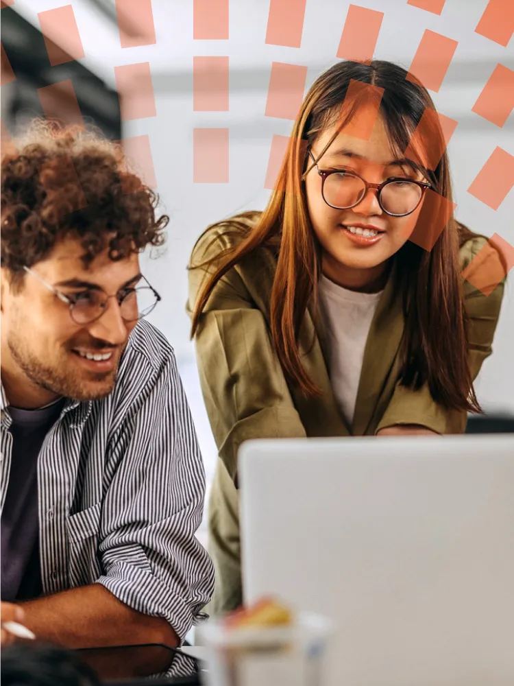 Colleagues standing around computer chatting