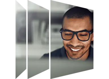 A man with glasses smiling brightly.