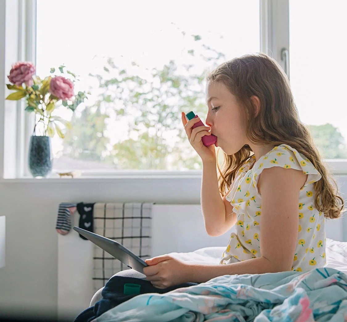 Young girl with pink asthma inhaler