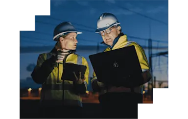 Woman and man on construction site holding laptops