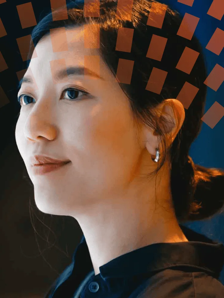 Asian woman holding phone in front of digital display