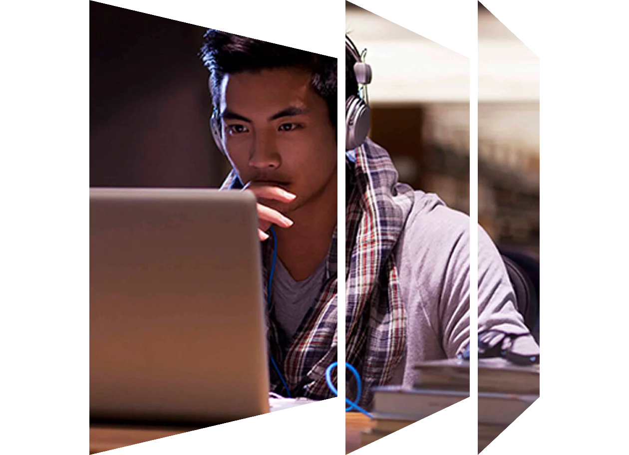 Male student wearing headphones on laptop