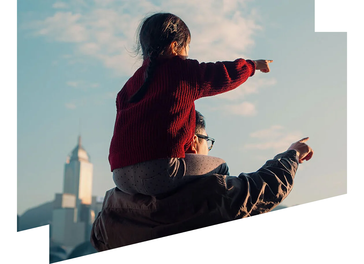 Child sitting on father's shoulders. Both pointing ahead.