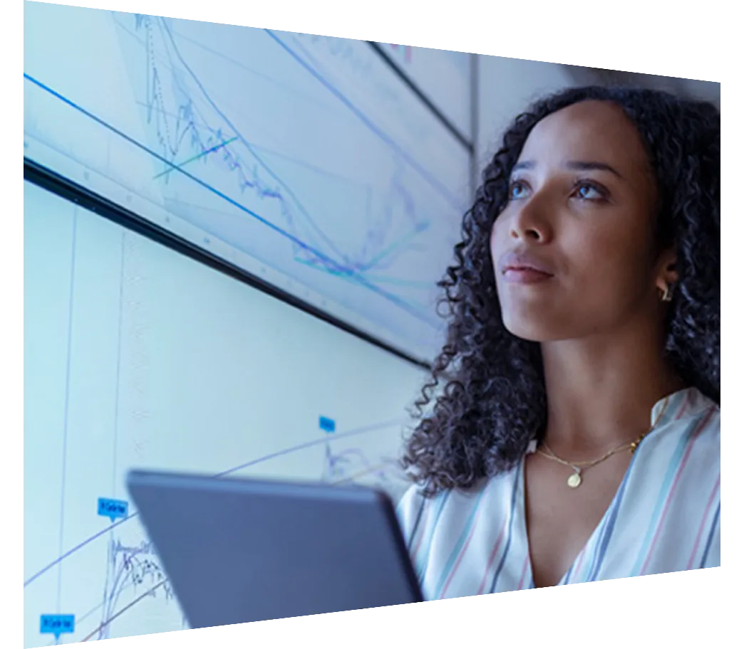 Female researcher with tablet in front of screen with analytics