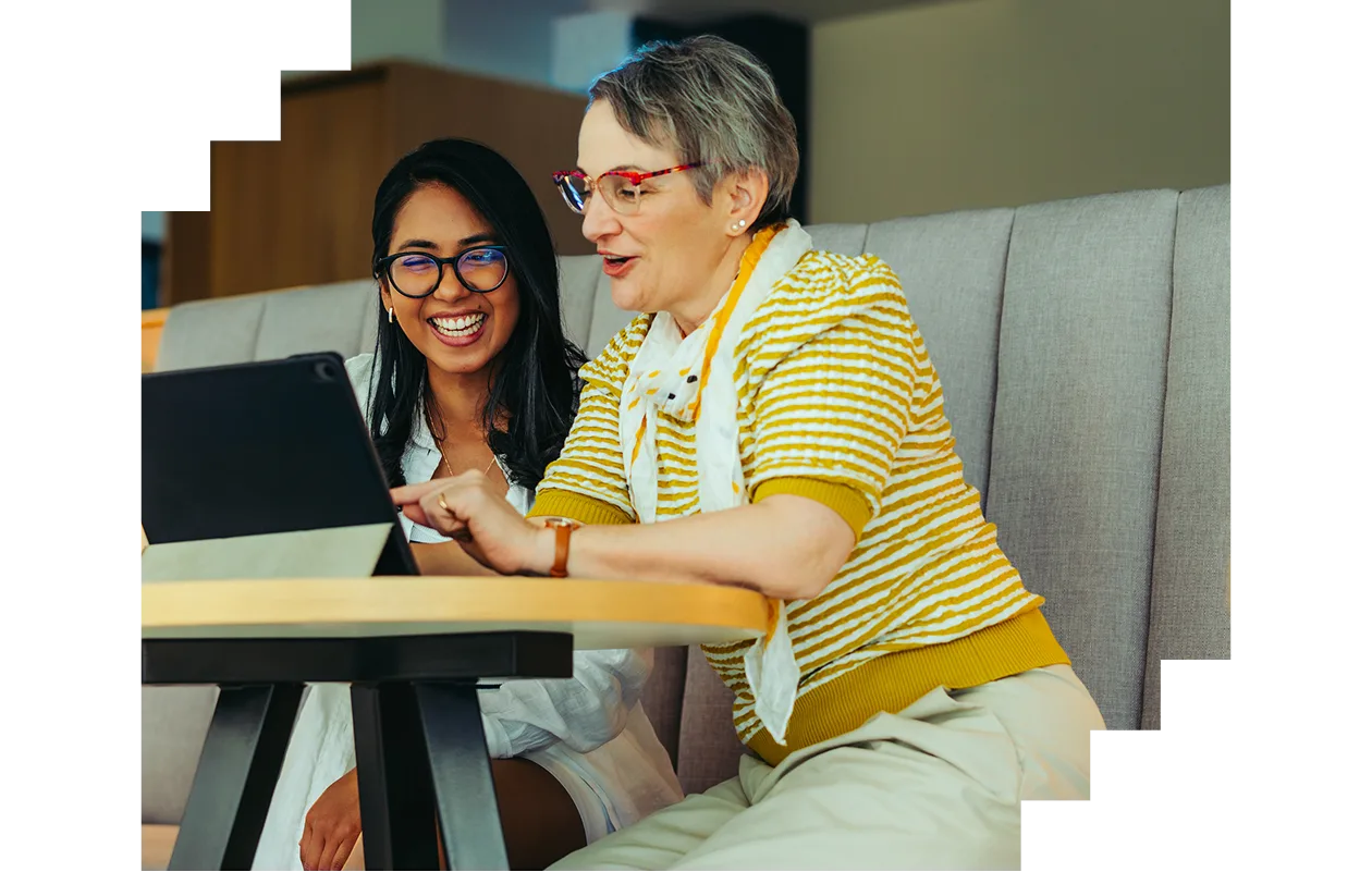 Teacher mentoring student with tablet in modern university environment