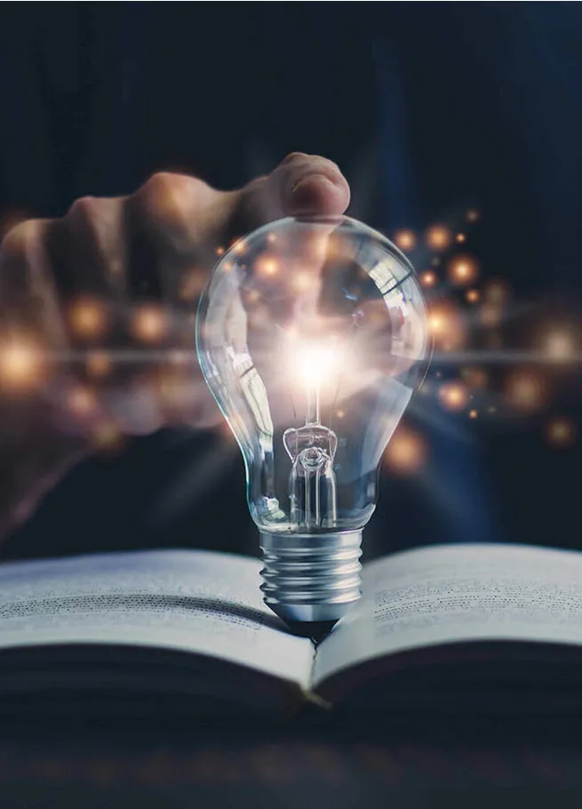 Glowing light bulb and book
